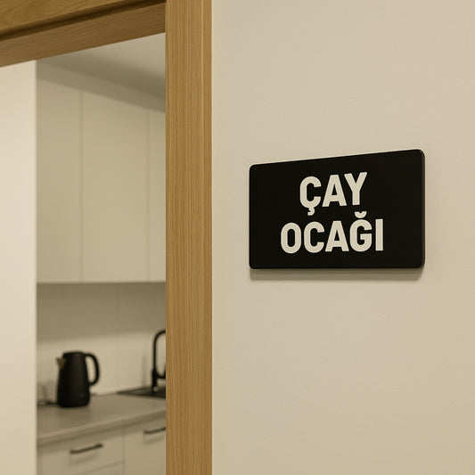 Çay Ocağı yazılı siyah pleksi tabela, mutfak duvarına monte edilmiş kullanım örneği