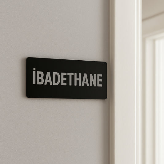 İbadethane yazılı siyah pleksi tabela, duvara monte edilmiş kullanım örneği