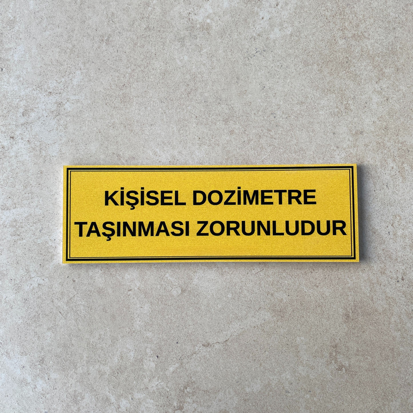 30x10 cm kişisel dozimetre zorunlu kullanım uyarı levhası beton yüzey üzerinde