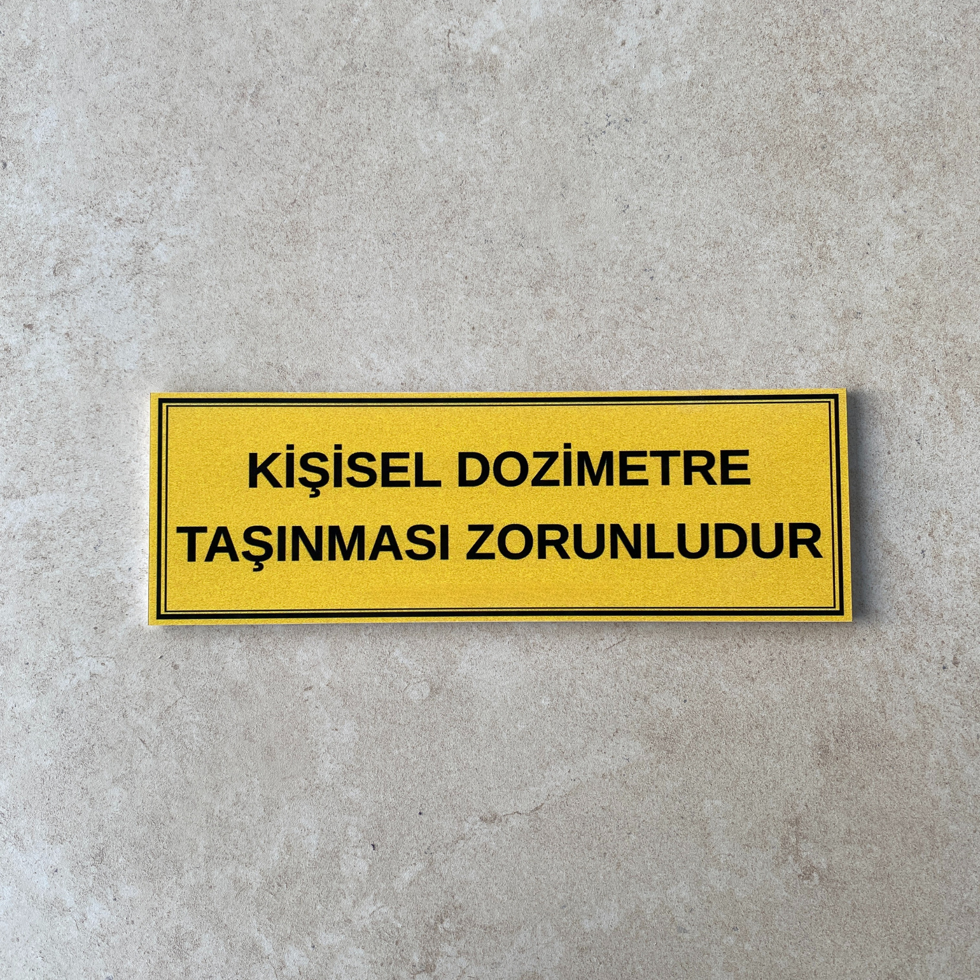 30x10 cm kişisel dozimetre zorunlu kullanım uyarı levhası beton yüzey üzerinde