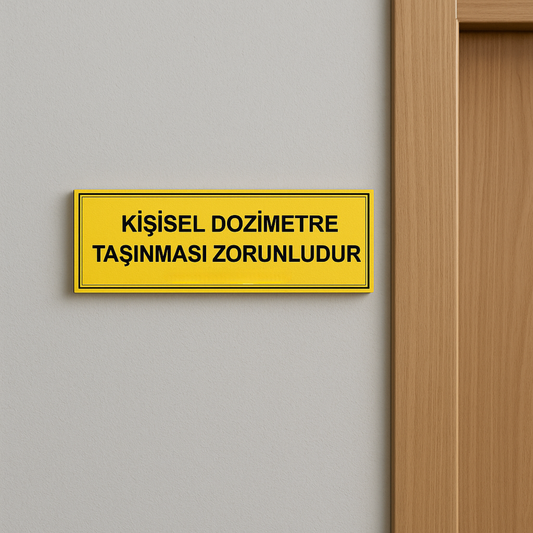 Kişisel Dozimetre Taşınması Zorunludur tabelası kapı yanı duvara monte edilmiş kullanım görseli