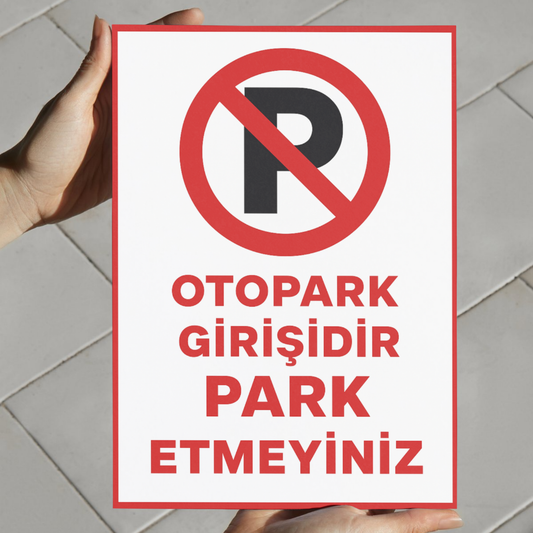 Elde tutularak boyutu gösterilen, kırmızı çerçeveli “Otopark Girişidir Park Etmeyiniz” yazılı 25x35 cm uyarı levhasının yakın plan görünümü