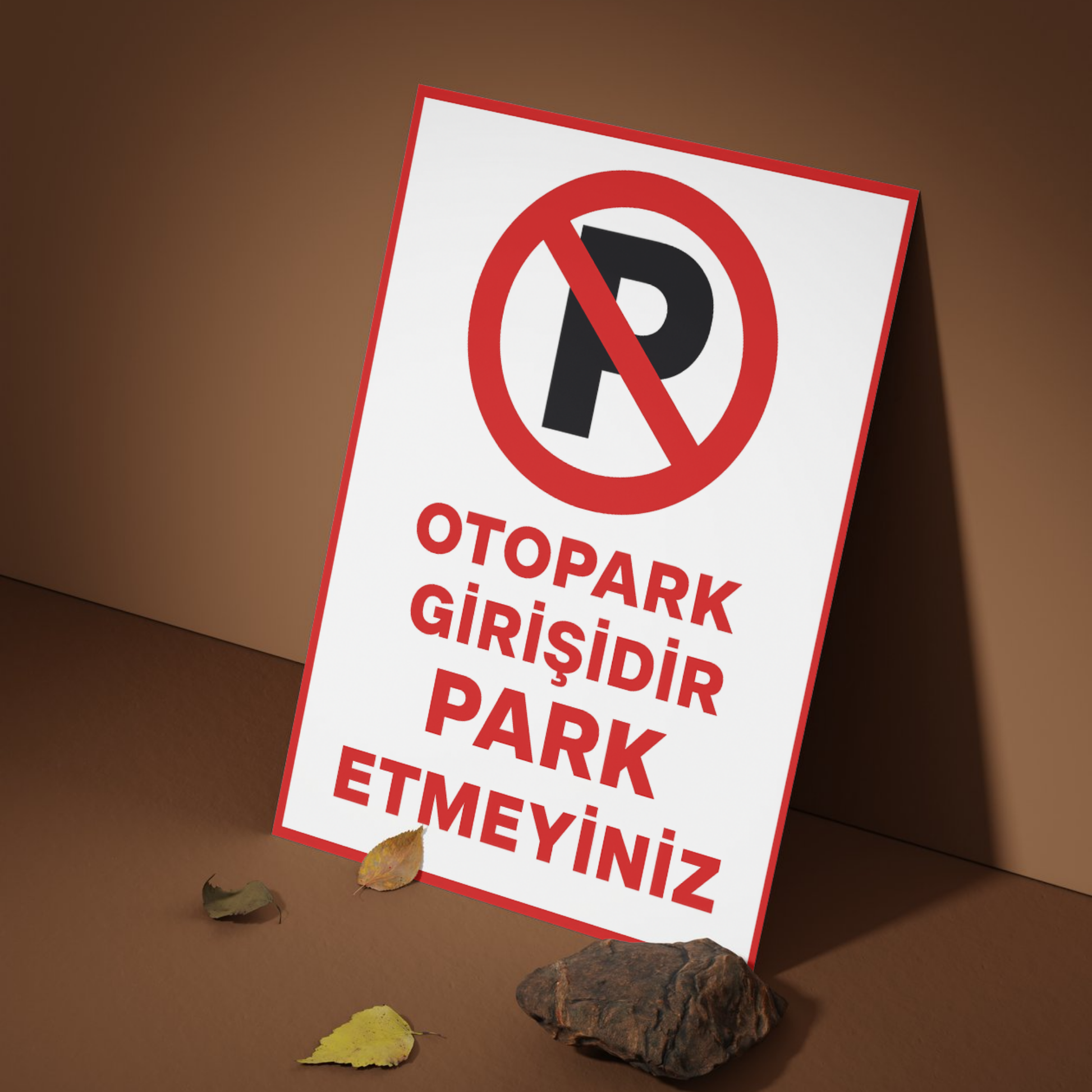 Otopark girişinde zemine yaslanmış şekilde sergilenen, kırmızı çerçeveli “Otopark Girişidir Park Etmeyiniz” yazılı 25x35 cm uyarı levhasının kullanım örneği