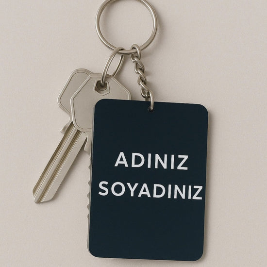 Kişiye özel dikdörtgen siyah pleksi anahtarlık ev anahtarıyla sallanıyor