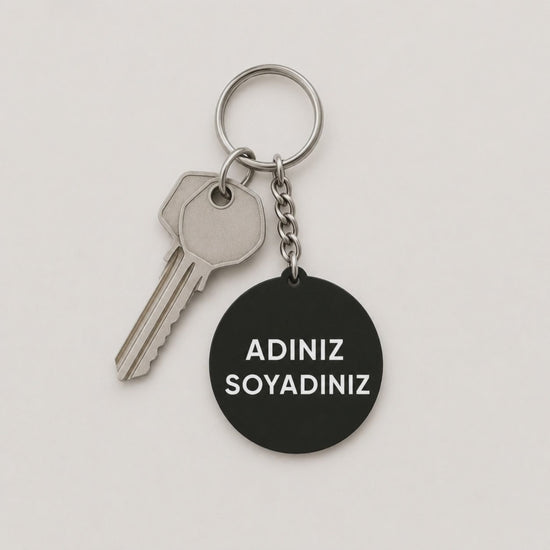Kişiye özel yuvarlak siyah pleksi anahtarlık tek ev anahtarıyla yakın çekim