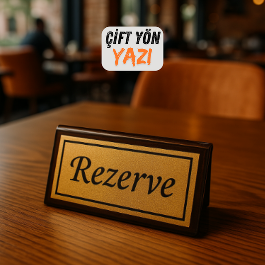 Çift yön rezerve masa üstü yazısı, siyah zemin gold baskı, restoran masasında yakın çekim